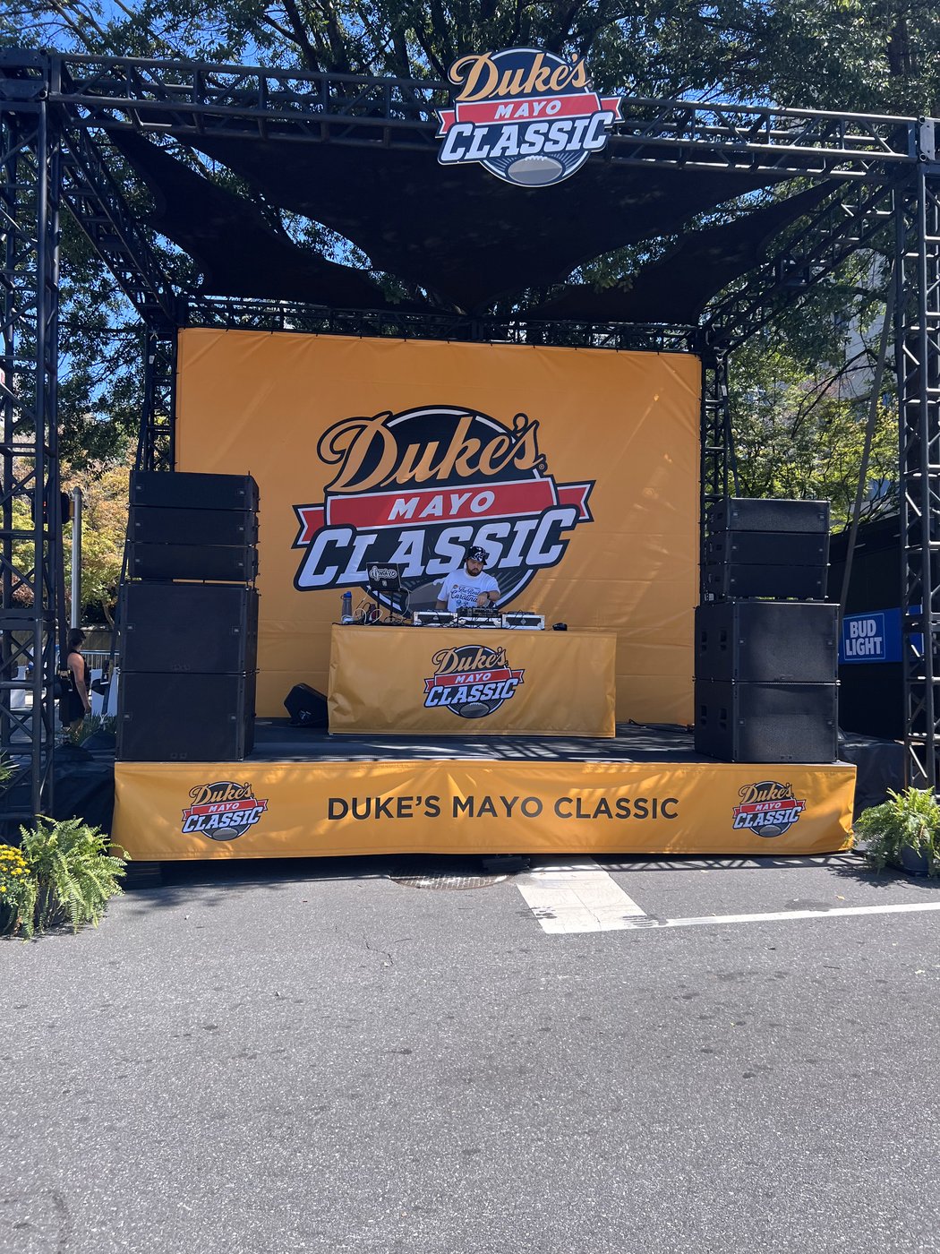 Duke's Mayo Classic branded stage built from black truss with a yellow banner backdrop and speaker stacks