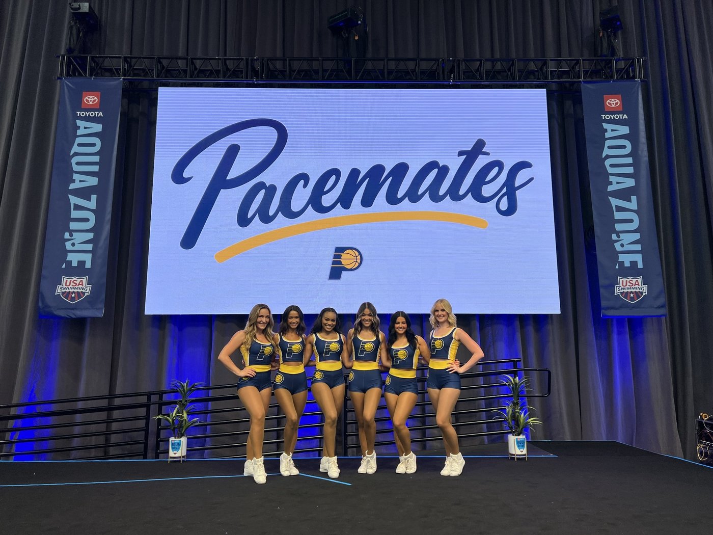 Indiana Pacemates dance team posed in front of a Pacemates logo on the Aqua Zone screen