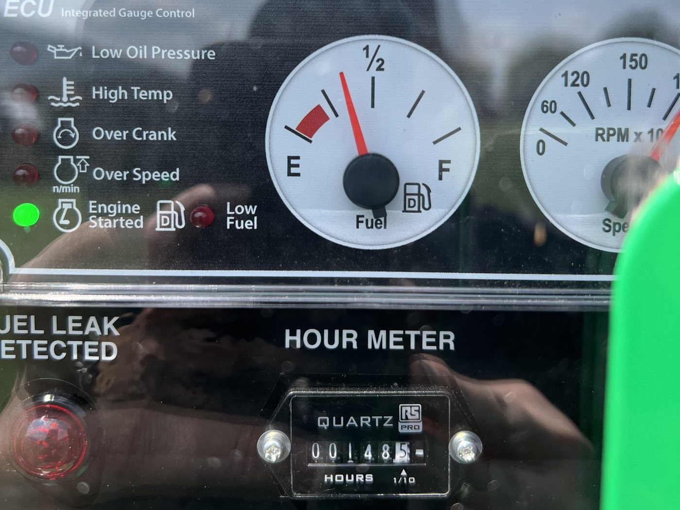 Close-up of a generator control panel with the fuel gauge needle near empty